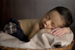 A picture of a child sleeping on a blanket.